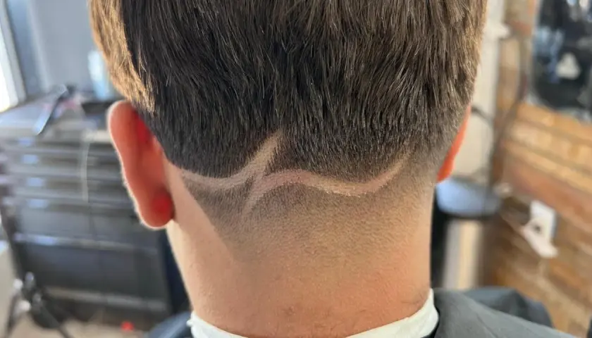 Corte de pelo con diseño en zig-zag y un taper fade impecable en la nuca.