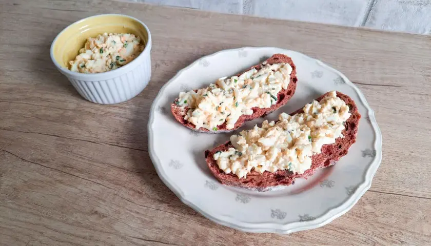 Pyszna pasta jajeczna ze szczypiorkiem na ciemnym pieczywie. Idealna na śniadanie lub przekąskę.