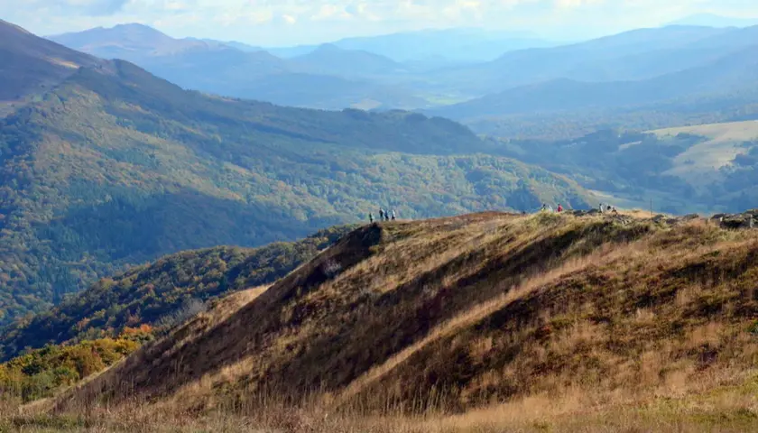 Widok na Bieszczady Połonina Wetlińska. Grupa turystów podziwia jesienne krajobrazy górskie.