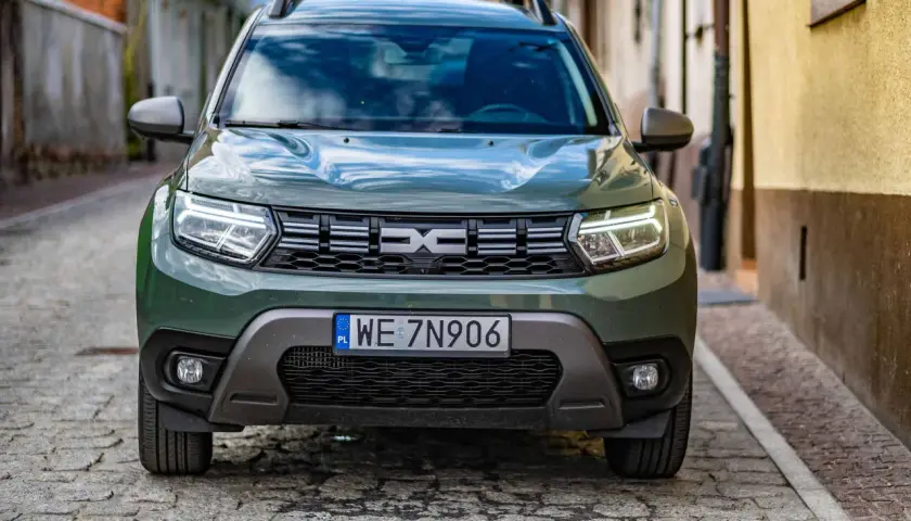 Zielony Dacia Duster na brukowanej uliczce. Sprawdź, jakie jest dacia duster spalanie i wybierz się na przygodę.