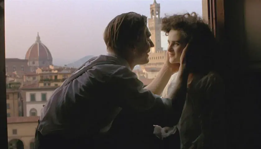 Ett par kysser varandra med Florens silhuett i bakgrunden, en ikonisk scen från en toscana film.
