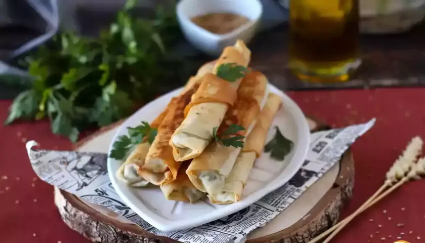 Rollitos crujientes de pasta filo rellenos, listos para disfrutar. Los ingredientes básicos para esta delicia son la pasta filo, un relleno sabroso y aceite.