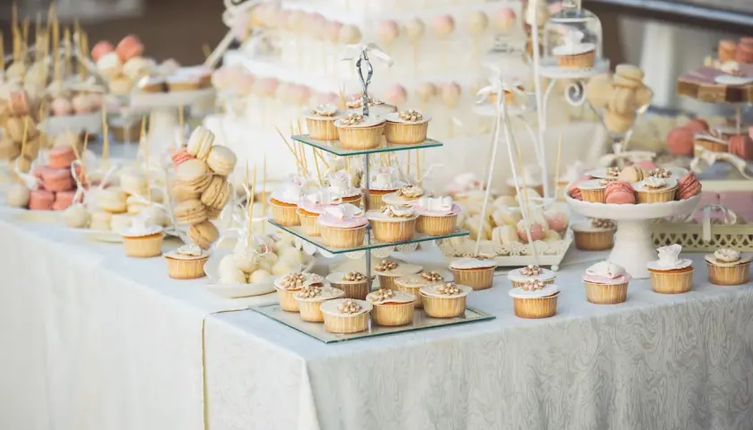 Un magnifique buffet de mariage avec une idée de présentation de desserts : cupcakes, macarons, cake pops et une pièce montée.
