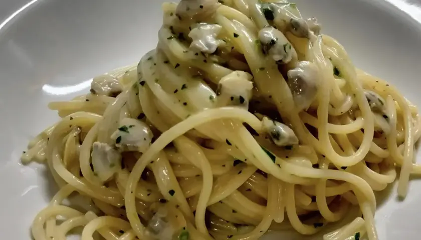 Spaghetti alle vongole cremosi come al ristorante, un piatto invitante con pasta e molluschi in una salsa vellutata.