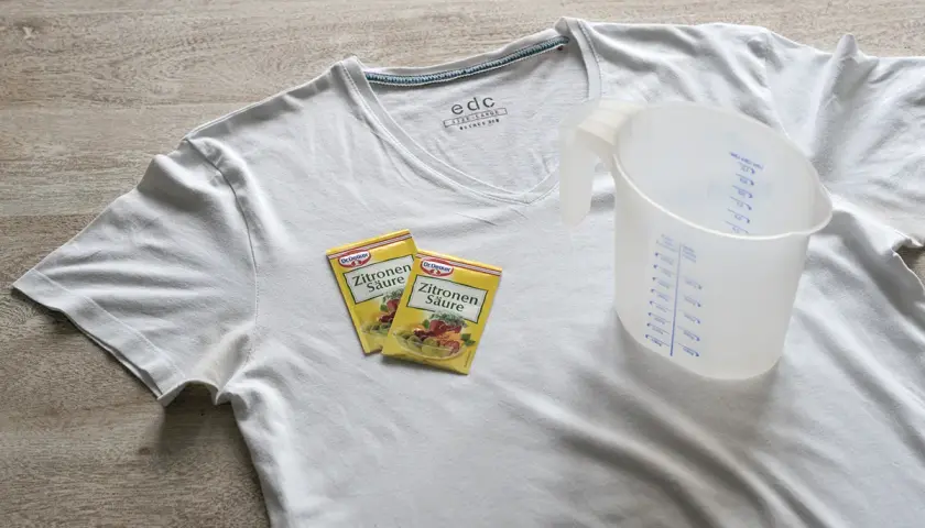 Weiße T-Shirts mit gelben Achselflecken? Zitronensäure und ein Messbecher liegen bereit, um die Flecken zu entfernen.