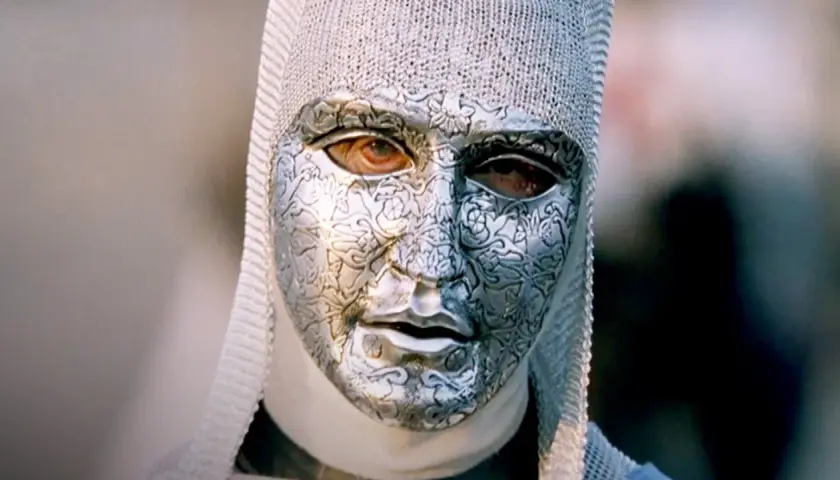 En mystisk figur med en detaljerad silvermask och kedjehätta, en karaktär från rollistan i Kingdom of Heaven.