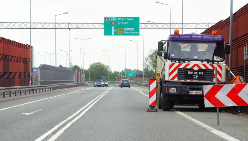 Ciężarówka MAN blokuje drogę, ostrzegając przed wyprzedzaniem na podwójnej ciągłej. Mandat za takie wykroczenie jest wysoki.