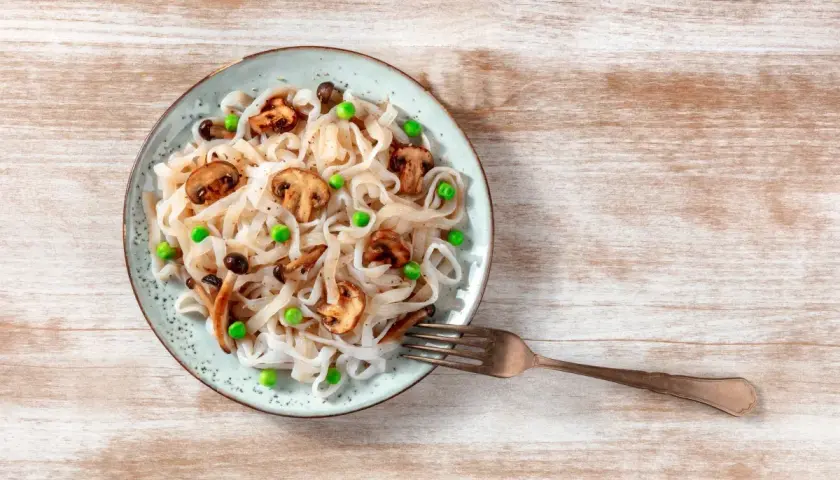 Makaron konjac z pieczarkami i groszkiem na talerzu. Inspiracja na zdrowe przepisy.