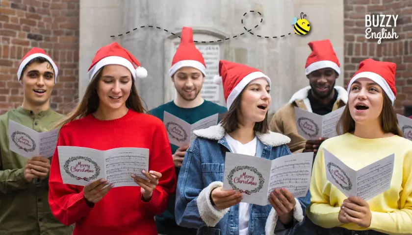 Giovani con cappelli natalizi cantano "le più belle canzoni di natale in inglese" da spartiti con "Merry Christmas".