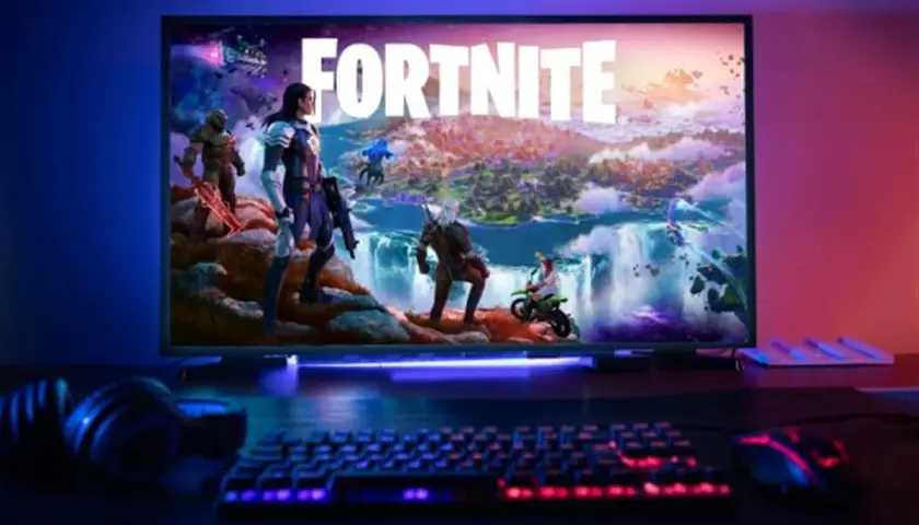 Écran affichant Fortnite avec des personnages, un clavier et une souris éclairés, prêt pour une configuration PC gaming.