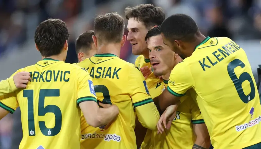 Piłkarze GKS Katowice świętują bramkę w meczu z Wisłą Płock. Radość na twarzach zawodników, numery 15, 9, 6 widoczne na koszulkach.