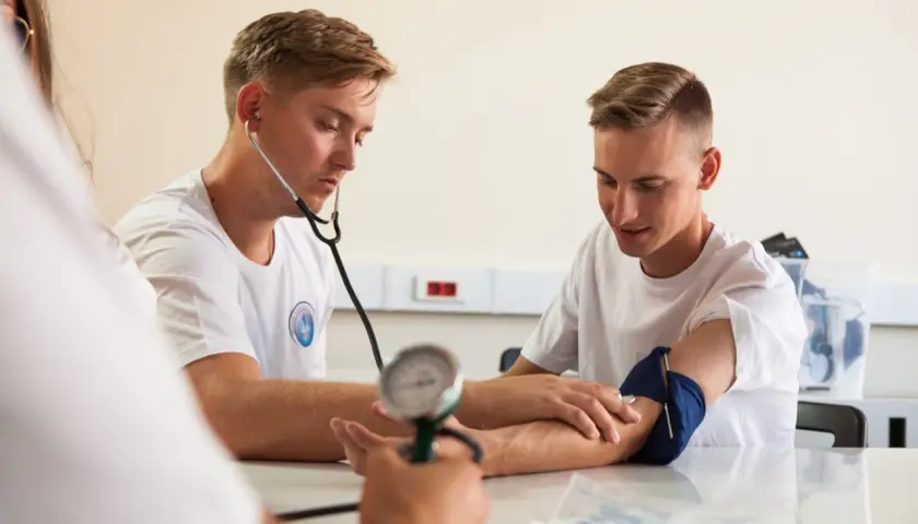 Opiekun medyczny mierzy ciśnienie, wspierając promocję zdrowia i profilaktykę.