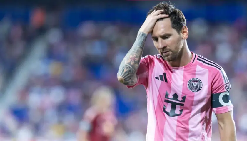 Lionel Messi w różowej koszulce Interu Miami, z ręką na głowie, wyraża zmartwienie. Czyżby to była **messi kontuzja**?