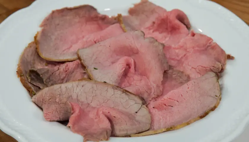 Fette di roast beef rosa e succulento, pronte per essere gustate. Una deliziosa roast beef ricetta.