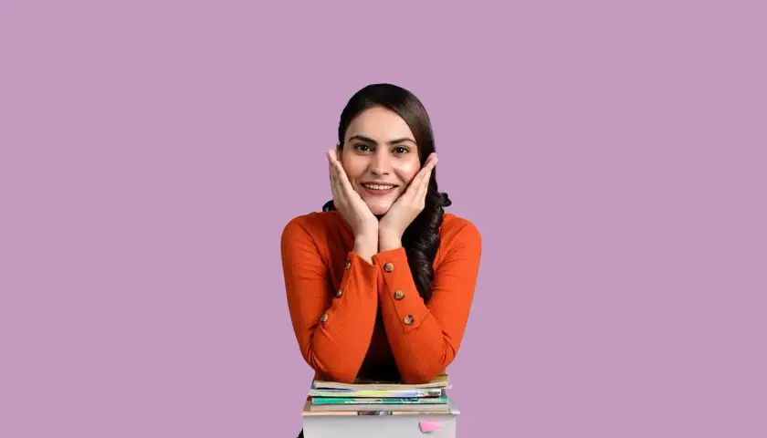 Ragazza sorridente con le mani sulle guance, appoggiata a una pila di libri. "Wow!" esclamazioni in inglese.