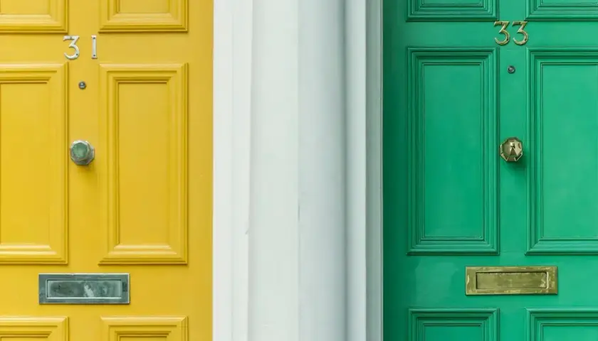 Dwie drzwi zewnętrzne, żółte i zielone, z numerami 31 i 33. Zastanawiasz się, czym pomalować drzwi zewnętrzne?