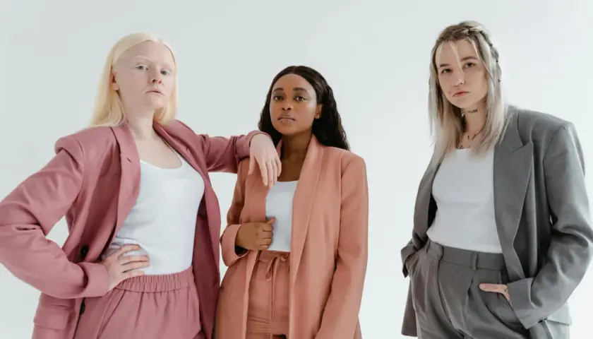 Three diverse women in stylish suits, embodying the spirit of a female leadership program.