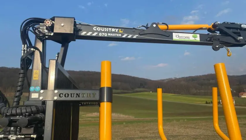 Ein COUNTRY 670 MASTER Kran mit Seilwinde und Funksteuerung steht bereit für den Holzeinsatz.