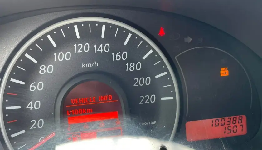 Kontrolki na desce rozdzielczej Nissan Micra: świeci się kontrolka kluczyka, wskazówka prędkościomierza na 0, a przebieg to 100388 km.