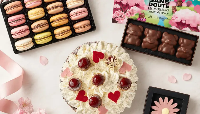 Un délicieux dessert pour la fête des grands-mères : une tarte garnie de fruits rouges et de crème, accompagnée de macarons colorés et de chocolats en forme d'oursons.