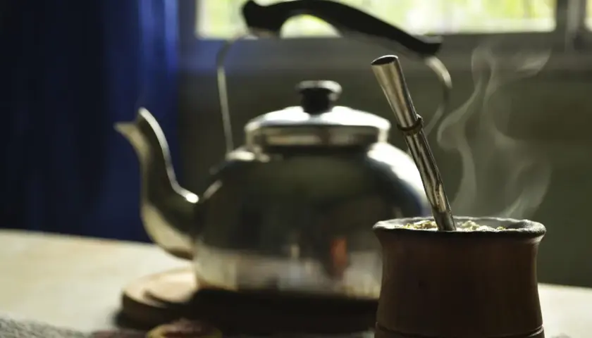 Gorąca yerba mate w drewnianym naczyniu, obok czajnik. Idealny napój, by zastanowić się, ile yerby dziennie wypić.