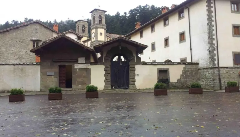 Cortile umido con foglie cadute davanti all'ingresso di Camaldoli, dove si trova questo antico eremo.