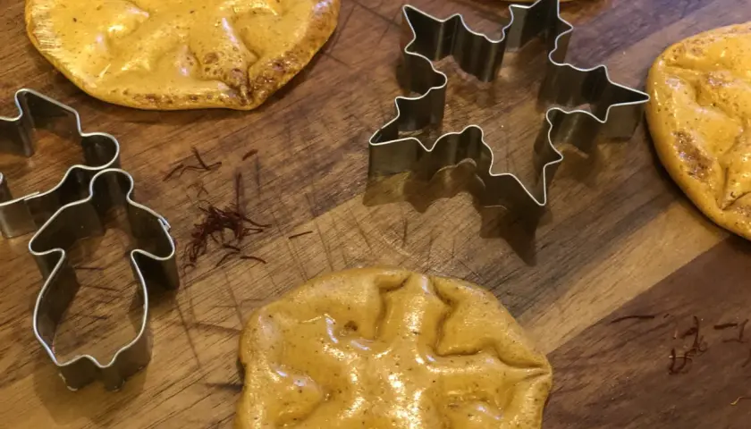 Dalgona-kakor med stjärn- och pepparkaksgubbeformar, redo att bakas.