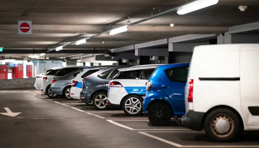 Rząd samochodów na parkingu podziemnym, gdzie czujnik parkowania do garażu ułatwia manewrowanie.