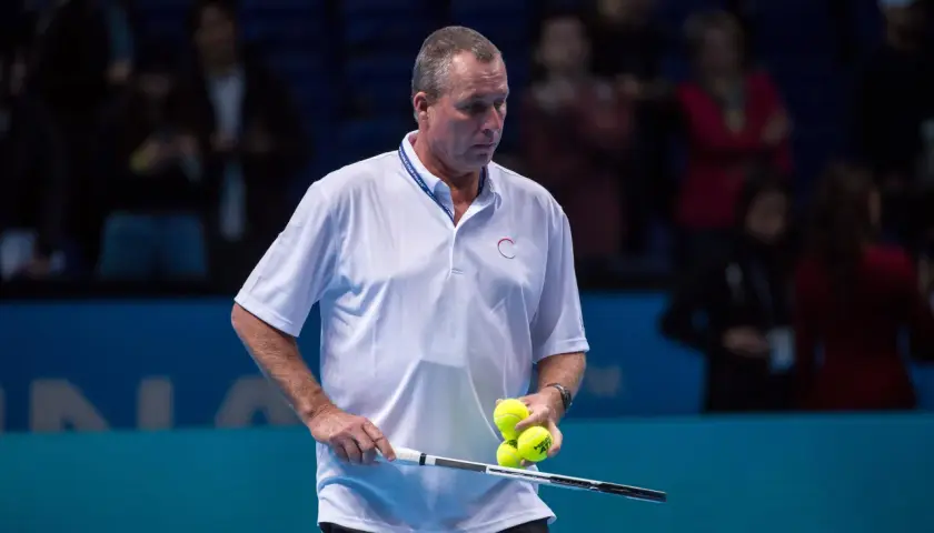 Ivan Lendl, były tenisista, trzyma rakietę i piłki tenisowe na korcie.
