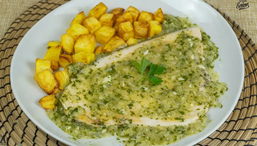 Delicioso emperador a la plancha bañado en salsa verde con patatas fritas crujientes.