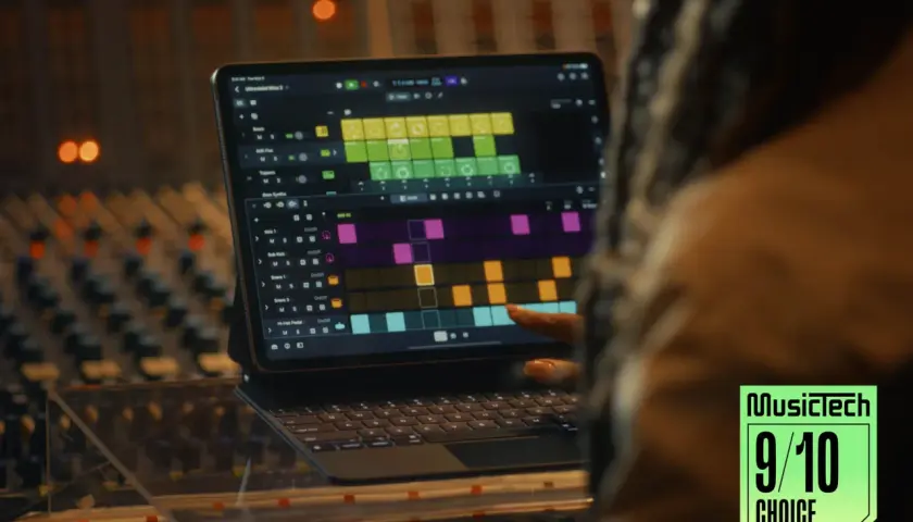 Ein Finger tippt auf einem iPad mit Logic Pro auf eine Drum-Spur. Ein Musikproduzent arbeitet im Studio.