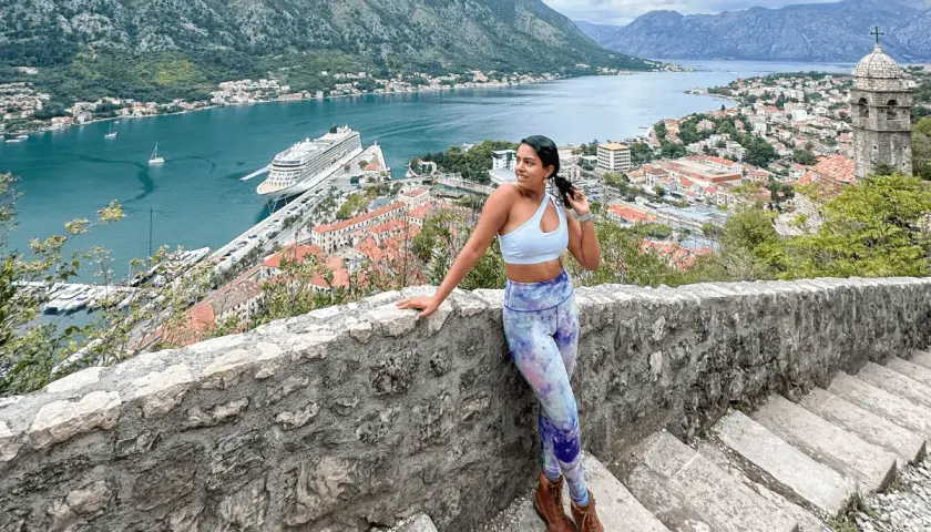 Woman on stone steps overlooking Kotor Bay, Montenegro. A perfect view for anyone planning a trip to Montenegro.