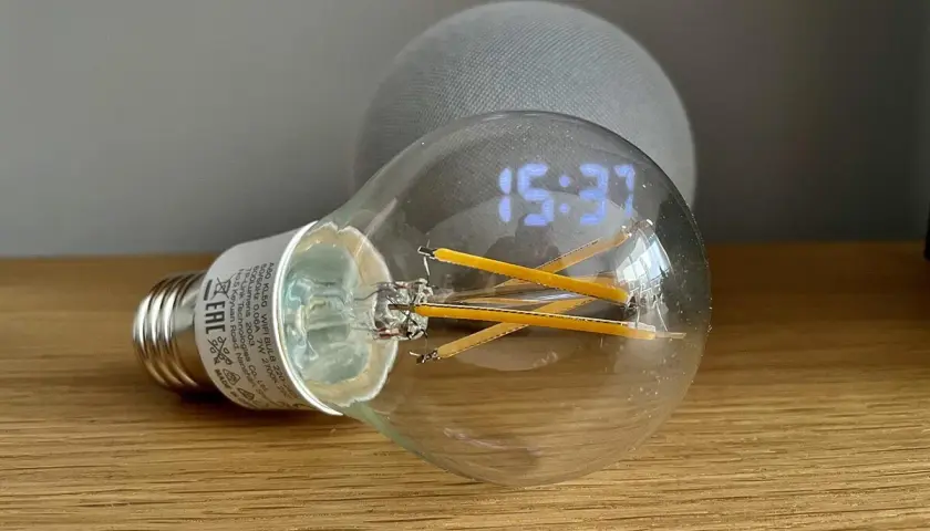 Bombilla inteligente con reloj digital y un dispositivo Echo Dot. Aprende como hacer que Alexa encienda la luz.