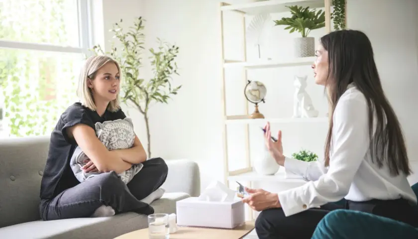Rozmowa terapeutyczna. Kobieta opowiada o swoich problemach, szukając odpowiedzi, jak zostać psychoterapeutą.
