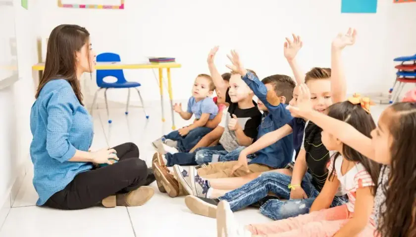 Nauczycielka pyta dzieci, ile trzeba mieć frekwencji żeby zdać. Wszyscy podnoszą ręce, chętni do odpowiedzi.