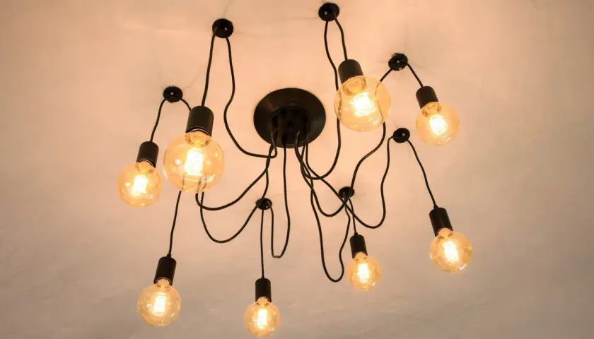 Nowoczesna lampa sufitowa z wieloma żarówkami. Dowiedz się, jak przesunąć lampę sufitową bez kucia, wykorzystując jej elastyczną konstrukcję.