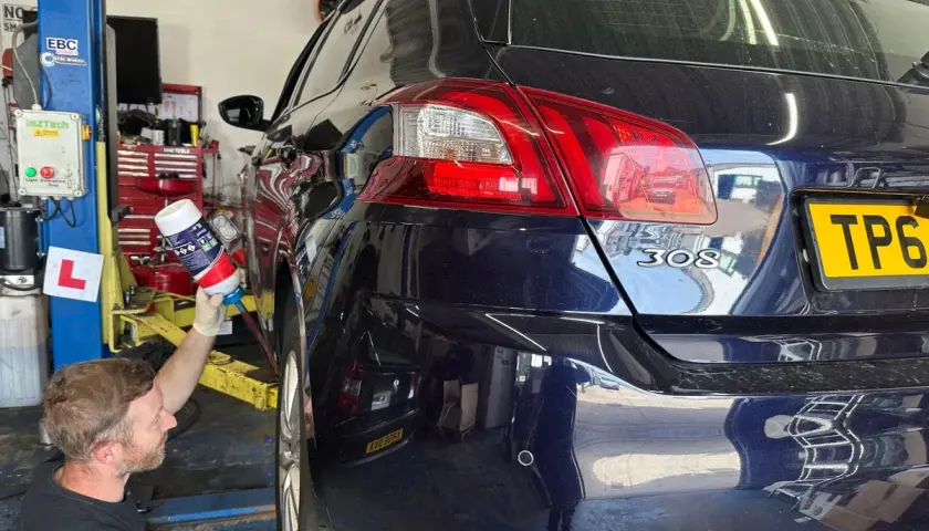 Mechanik używa sprayu do czyszczenia, gdy na desce rozdzielczej świeci się kontrolka "brak płynu fap".
