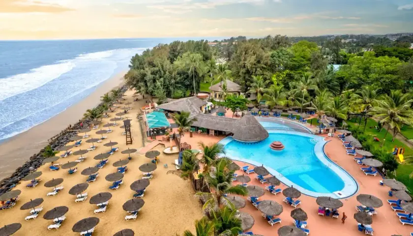 Rajskie wakacje w Gambii: plaża, basen i palmy tworzą idealne miejsce na relaks.
