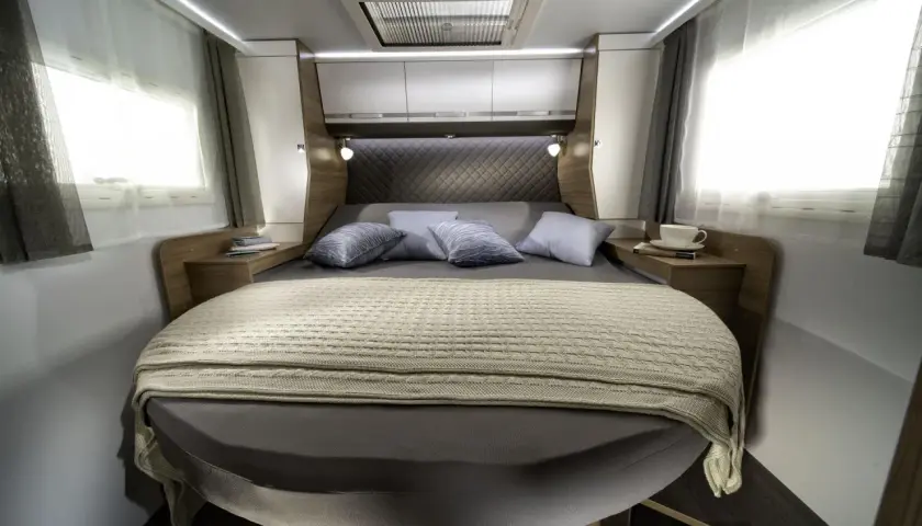 Lit transversal confortable dans un camping-car, prêt pour une nuit paisible.