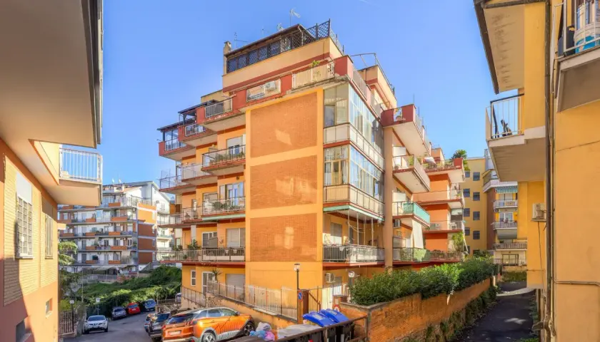 Edifici residenziali colorati nel quartiere Ottavia, con balconi e auto parcheggiate.