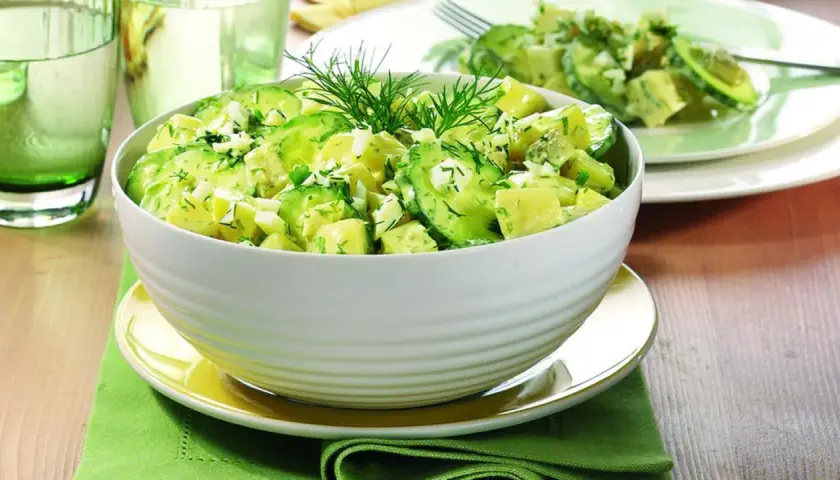 Ein cremiger italienischer Kartoffelsalat mit Avocado, Ei und frischen Kräutern, garniert mit Dill.