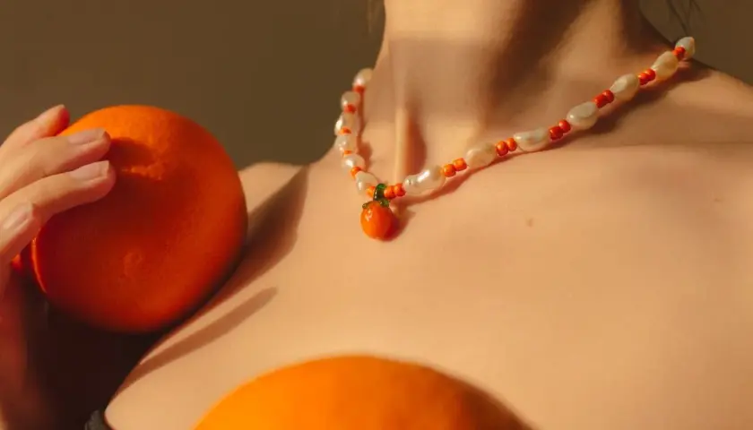 Collar de perlas y cuentas naranjas con un colgante de mandarina, como si fuera un sueño con naranjas.