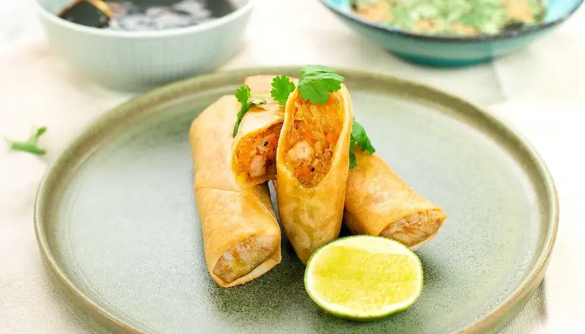 Krispiga vårrullar med räkfyllning, serverade med lime och dippsåser. Ett perfekt vårrullar recept för hemmakockar.