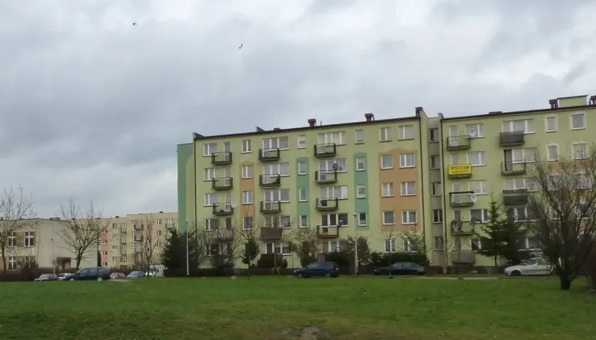 Bloki mieszkalne w Łodzi, z widocznym szyldem "SPRZEDAM". Ceny mieszkań w Łodzi mogą być różne, ale te budynki wyglądają na typowe dla osiedli z lat 70.