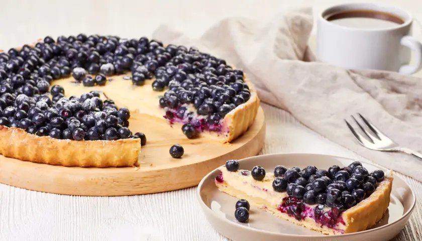 Tarta z owocami i budyniem Ani. Pyszna, domowa tarta z jagodami i kremowym budyniem, posypana cukrem pudrem. Idealna na deser.