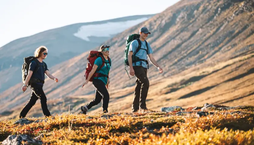 Vandrare njuter av en solig dag på fjället, kanske på väg mellan Saltoluokta och Kvikkjokk.