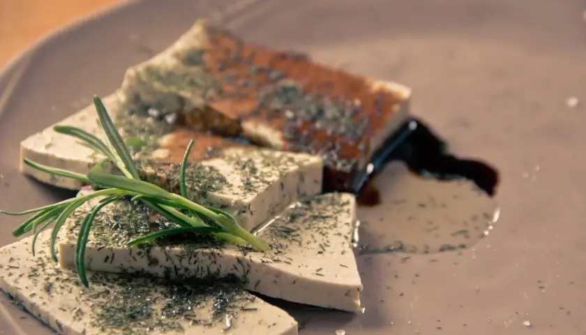 Pokrojone w kostkę tofu, posypane ziołami, z gałązką rozmarynu. Idealne tofu dla niemowlaka, zdrowe i smaczne.