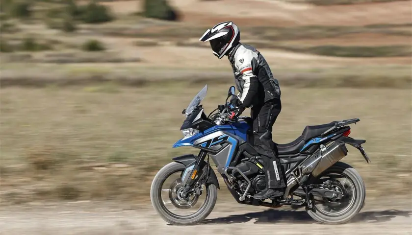 Motociclista en una Voge 650 DSX azul, probando sus capacidades off-road. Las voge 650 dsx opiniones son positivas.