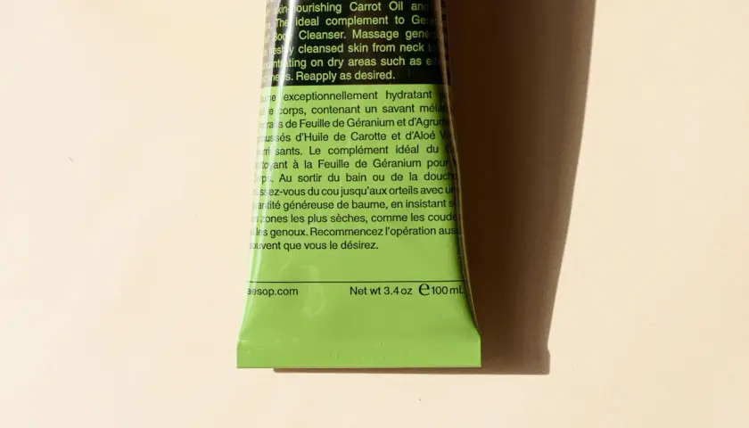 Zieleń tubki z tekstem w języku angielskim i francuskim. Analiza składu wskazuje na geranium, cytrusy i marchew.
