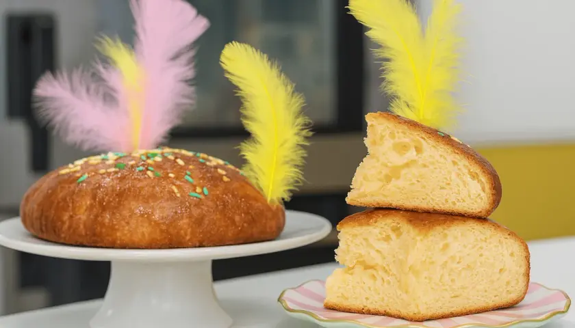 Deliciosa receta mona de pascua esponjosa, decorada con plumas de colores y chispas. ¡Perfecta para compartir!